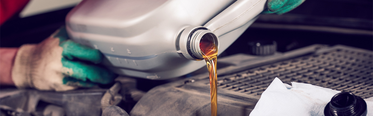 Mechanic pouring engine oil into a vehicles engine - Car Servicing Preston